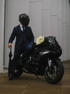 Vīrietis uzvalkā uz motocikla BG Uzvalki