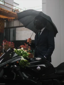 Vīrietis uzvalkā ar lietussargu